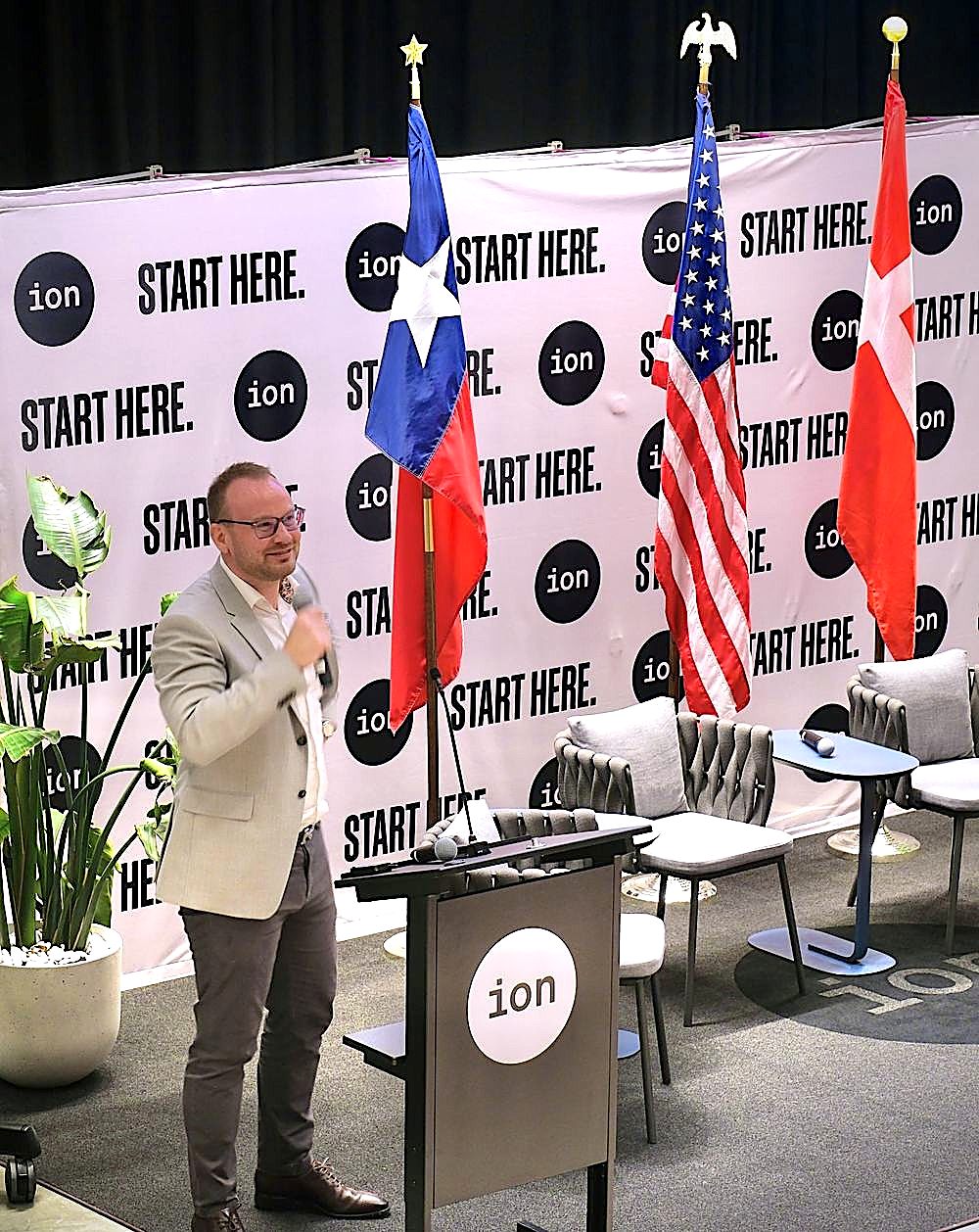 Thomas Tougaard speaking at The Ion, Houston, with the Texan, American, and Danish flags